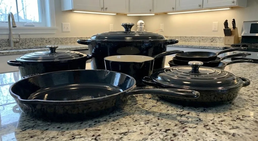 Cast iron cookware set with skillets and pots displayed on a kitchen surface